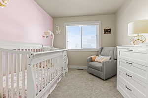 Bedroom 2, featuring a nursery area and light carpet