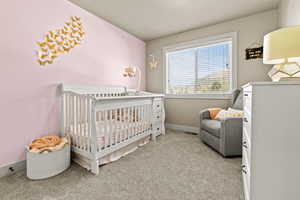 Bedroom 2, featuring a nursery area and light carpet