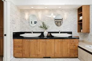 Bathroom featuring recessed lighting, double vanity, and a bath