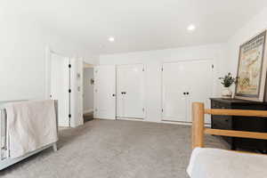 Bedroom featuring multiple closets, carpet floors, and recessed lighting