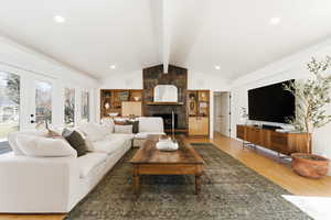 Living room with light wood-style flooring, beamed ceiling, french doors, recessed lighting, and a fireplace