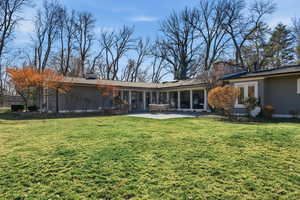 Rear view of house with a chimney, french doors, and a yard