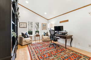 Home office with vaulted ceiling, light wood-style flooring, and recessed lighting