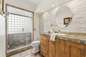 Bathroom with vanity, a stall shower, and recessed lighting