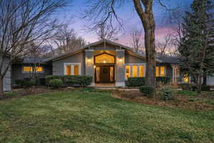 Mid-century modern home with stucco siding and a front yard