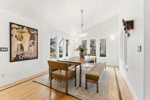 Dining area with lofted ceiling and light wood-style flooring
