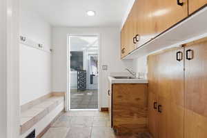Mudroom with a sink and stone tile flooring