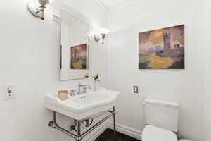Half bath featuring toilet and baseboards