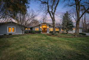 View of front facade with stucco siding, a front lawn, and an attached garage