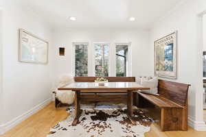 Dining area featuring light wood-style floors, crown molding, breakfast area, and recessed lighting