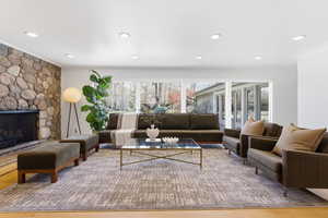 Living area with crown molding, a fireplace, light wood-style floors, and recessed lighting