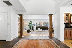 Entrance foyer with ornate columns and stone tile flooring