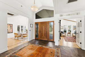 Entrance foyer featuring stone tile floors, plenty of natural light, and vaulted ceiling