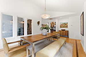 Dining area with light wood-style flooring, vaulted ceiling, and recessed lighting