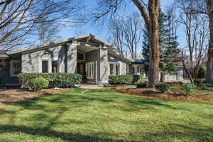 View of front of house featuring a front lawn and stucco siding