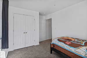 Carpeted bedroom featuring a closet and baseboards