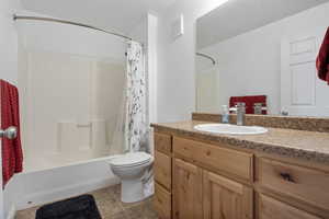 Bathroom with vanity, shower / bathtub combination with curtain, and light tile patterned flooring
