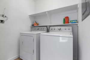 Laundry area featuring separate washer and dryer and baseboards