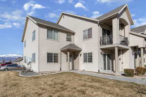 View of front of house featuring a balcony, a shingled roof, and a front lawn