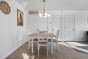 Dining area with a chandelier and tile patterned flooring