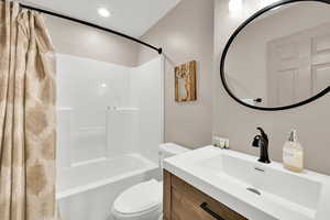 Bathroom with shower / bathtub combination with curtain, vanity, and recessed lighting