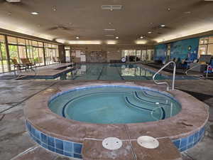 Indoor community pool featuring a hot tub