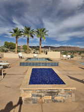 View of pool featuring an in-ground hot tub, a mountain view, and patio surround
