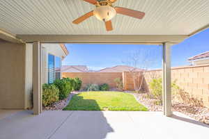 Fenced backyard featuring a ceiling fan and a expanded, covered patio