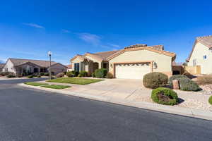 Mediterranean / spanish-style home featuring an attached garage, stucco siding, concrete driveway, a tiled roof, and a residential view