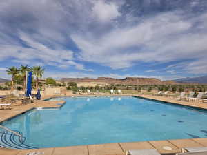 Community pool with a mountain view and a patio area