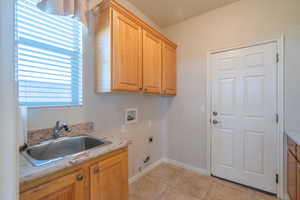 Laundry area with hookup for a washing machine, cabinet space, hookup for a gas dryer, and hookup for an electric dryer