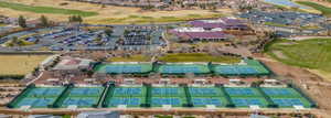 Aerial view of HOA amenites and surrounding area featuring a local golf course, multiple tennis & pickleball courts, and clubhouse