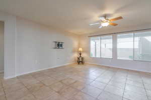 Living room with ceiling fan and light tile patterned floors