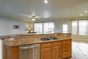Kitchen with a ceiling fan, stainless steel dishwasher, light tile patterned floors, open floor plan, and recessed lighting