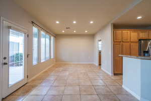 Dining Area off of Kitchen with granite counters, stainless steel refrigerator with ice dispenser, wood finish cabinetry, and recessed lighting