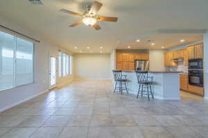 Tile Great Room with a breakfast bar, a center island, and recessed lighting