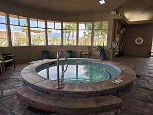 View of pool with a hot tub and a mountain view