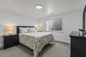 Bedroom with dark colored carpet and baseboards