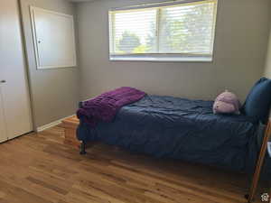 Bedroom with hardwood / wood-style floors and baseboards