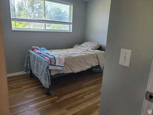 Bedroom featuring hardwood / wood-style flooring and baseboards