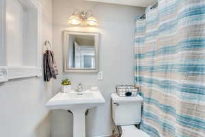 Full bathroom featuring toilet and a shower with shower curtain