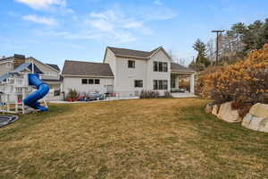 Back of property featuring a patio area, stucco siding, a playground, and a shingled roof