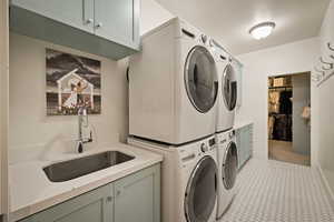 Laundry room featuring cabinet space and stacked washer / drying machine