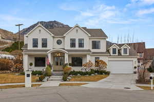 Traditional-style house with covered porch, driveway, roof with shingles, french doors, and a mountain view