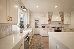 Kitchen featuring open shelves, stainless steel appliances, light wood finished floors, recessed lighting, and backsplash