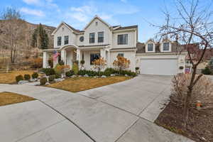 Traditional-style house featuring driveway, a porch, a front lawn, and a garage