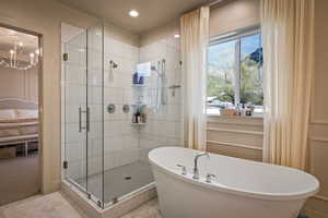 Ensuite bathroom featuring a shower stall, a freestanding tub, and recessed lighting