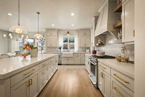 Kitchen featuring gas stove, light wood-type flooring, open shelves, and plenty of natural light
