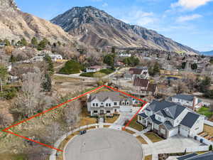 Aerial perspective of suburban area featuring property parcel outlined and a mountainous background