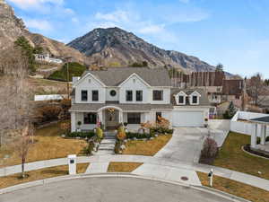 Traditional-style home featuring covered porch, concrete driveway, a mountain view, and roof with shingles